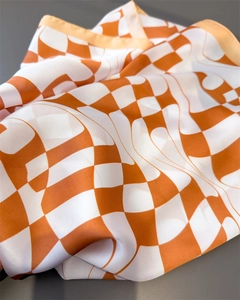 Detail of orange and white checkered silk scarf with premium smooth satin texture