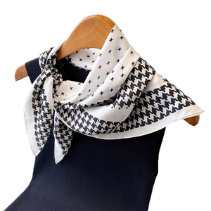 Carré de soie classique à motif pied-de-poule et étoiles sur un gilet noir