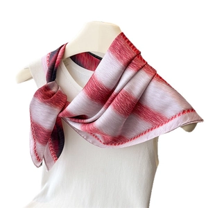 Classic red and white striped silk scarf tied on a white knit top for a premium look