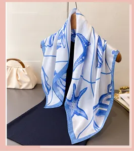 Detail of printed silk scarf with blue starfish patterns hanging on a wooden hanger