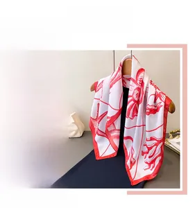 Detail of red marine pattern silk scarf with starfish and shells on wooden hanger