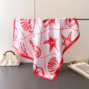 Close-up of red marine pattern silk scarf with starfish and shells on a light background