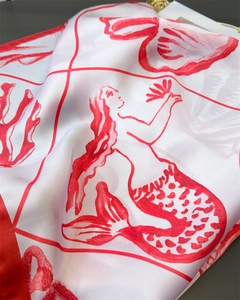 Detailed close-up of white silk scarf with red mermaid and coral prints for beach resort