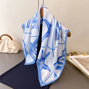 Elegant silk-like scarf with blue starfish and seashell prints on white fabric
