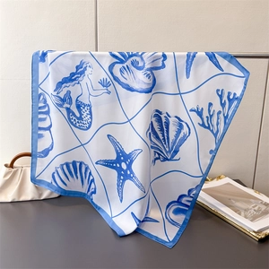 Detail showing high-quality silk scarf with blue ocean patterns and mermaid prints