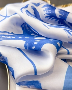 Close-up of silk-like scarf with blue starfish print and luxurious satin texture