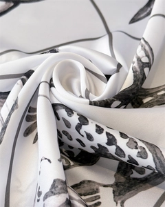 Detailed view of luxury satin fabric with elegant black and gray floral print texture
