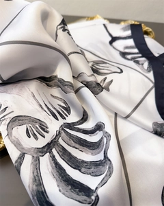 Detail of artistic ink print silk scarf showing soft satin luster and fine drapery
