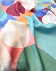 Detailed view of silky satin scarf with abstract geometric patterns and colorful blocks