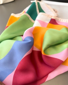 Detailed macro view of colorful geometric silk scarf with premium hand-rolled edges