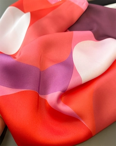 Detailed view of silk-like scarf with vibrant wavy geometric patterns and satin luster