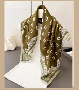 Scialle verde oliva con motivi a margherite e bordo paisley drappeggiato su manichino