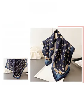 Dettaglio di un foulard quadrato blu scuro con eleganti motivi paisley e floreali