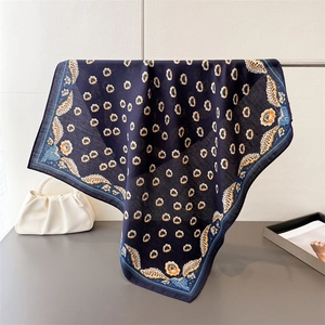 Dettaglio foulard quadrato blu scuro con stampa floreale su appendino in metallo