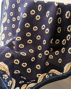 Dettaglio di sciarpa blu navy in cotone-lino con stampa a margherite e paisley