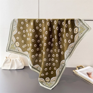 Dettaglio di sciarpa quadrata verde oliva con stampa margherite e bordi paisley