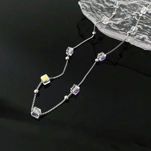 Titanium steel crystal bead necklace with iridescent cube charms on high-gloss black surface
