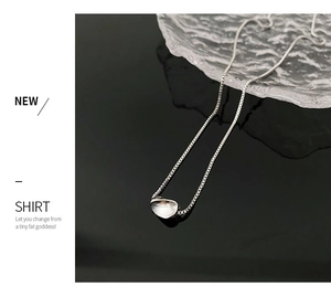 Close-up of silver geometric liquid metal pendant on adjustable box chain necklace
