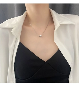 Close-up of minimalist silver geometric pendant on a sleek snake chain for women