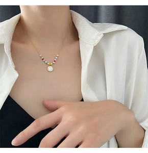 Detail of colorful bead necklace with smiley face pendant on a woman's neck