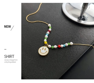 Detail of beaded necklace with pearls, colorful beads and a golden smiley face pendant