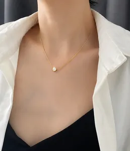 Detalle de un collar dorado minimalista con colgante de sonrisa usado por una modelo