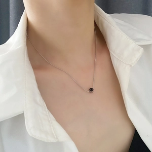 Collar con colgante de cara sonriente en acero de titanio sobre modelo con camisa blanca