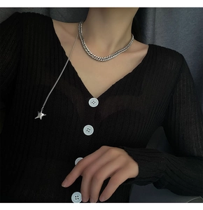 Silver chunky Cuban link chain with star pendant necklace on a black knit cardigan