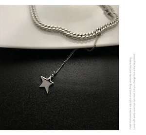Close-up of titanium steel Cuban chain with solid star pendant over a minimalist background