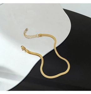 Detailed macro view of 18K gold plated snake chain anklet with lobster clasp and texture