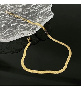 Detailed close-up of 18K gold-plated herringbone snake chain with lobster clasp and extender