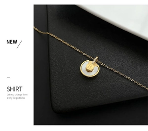 Gros plan d'un pendentif talisman doré avec nacre blanche et lettre B en cristaux