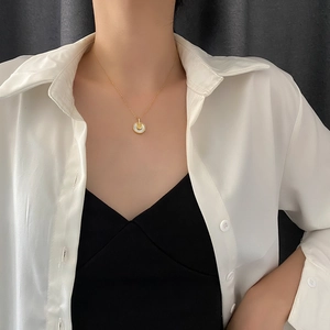 Collier amulette en acier titane doré élégant avec pendentif disque nacre blanche