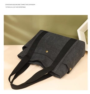 Détail montrant la texture en toile, la poignée noire et la boucle en métal doré du grand sac