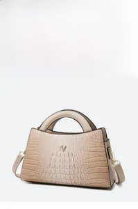 Detail view of crocodile pattern handbag with gold V-logo and detachable shoulder strap