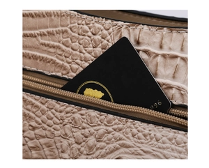Detail of crocodile embossed leather handbag with smooth zipper and internal pocket