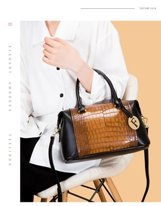 Detail of Boston bag showing faux crocodile texture and elegant gold logo charm