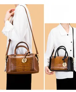 Detail of embossed crocodile pattern handbag with gold F pendant and long strap