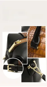 Detail view of gold-tone hardware and embossed crocodile texture on the tote bag