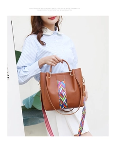 Braune Handtasche aus Leder mit Litschistruktur und farbenfrohem Schultergurt am Model