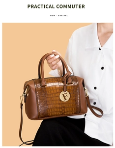 Detail of brown crocodile textured handbag with golden F pendant and sturdy handle