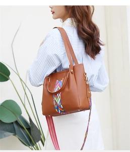 Detail der braunen Leder-Tote mit Litschi-Muster und buntem gewebtem Schultergurt