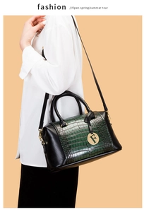 Detail of Boston-style handbag featuring green crocodile texture and gold F pendant