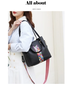 Detailansicht der schwarzen Lederhandtasche mit bunt gewebtem geometrischem Schultergurt