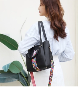 Modische schwarze Handtasche mit Kieselstruktur und buntem geometrischem Breitschultergurt