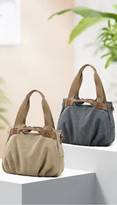Close-up of khaki and dark grey canvas tote bags with leather reinforcement details