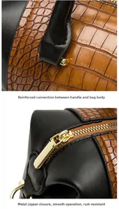 Close-up of reinforced handle stitching and golden zipper on black embossed boston bag