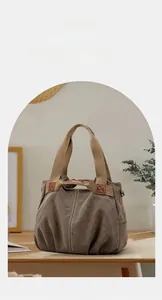 Detailed close-up of taupe canvas tote bag with contrast stitching and sturdy handle