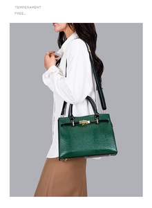 Macro detail of dark green embossed leather bag with gold buckle and leather strap