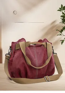 Detail of burgundy canvas tote bag showing khaki straps and adjustable metal hooks